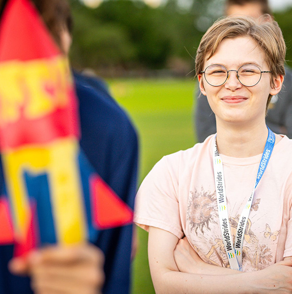 Student smiling next to another student holding a rocket